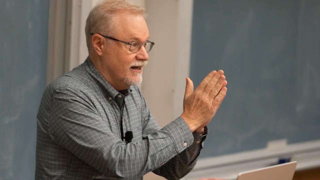 Professor Steven Luck teaching at the front of his classroom.