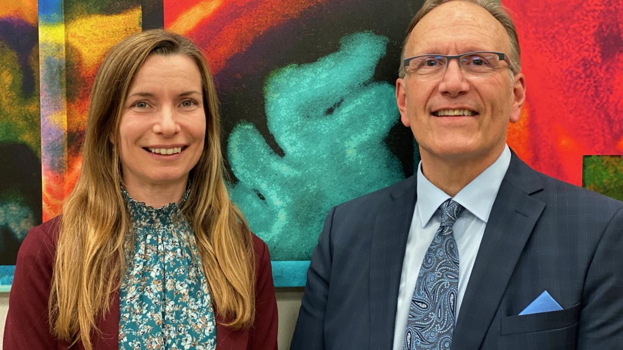 Amanda Guyer and Ron Mangun standing in front of a red painting